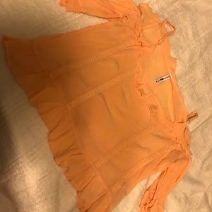 Orange shoulder-cut-out flowy top